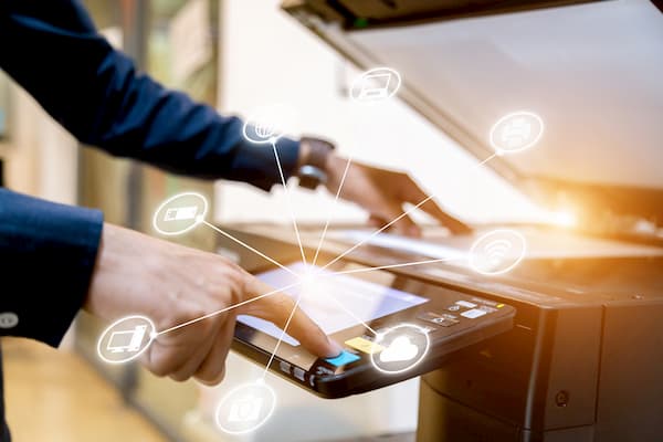 Man uses scanner to convert paper invoices into digital invoices with invoice management.