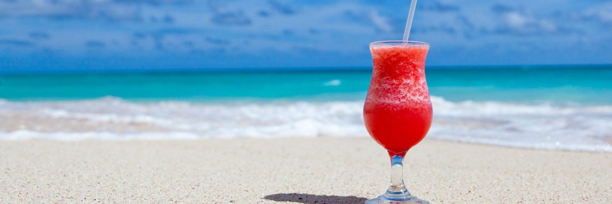 Cocktail op het strand om vakantie uit te beelden waarbij je eenvoudig facturen kunt goedkeuren met TriFact365.