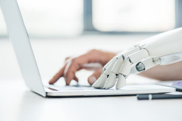Laptop mit Robothand als Beispiel für unsere Unternehmenssoftware