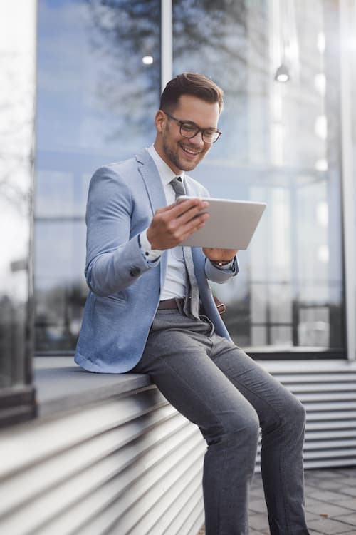 Un homme en veste et cravate regarde une tablette pour le logiciel Scan & Recognise.