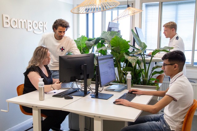 CEO Thomas and the BamBoek accounting team in the office behind computers.